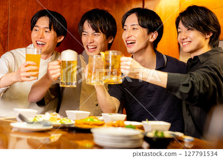 Young men toasting at an izakaya Young men toasting at an izakaya 127791534