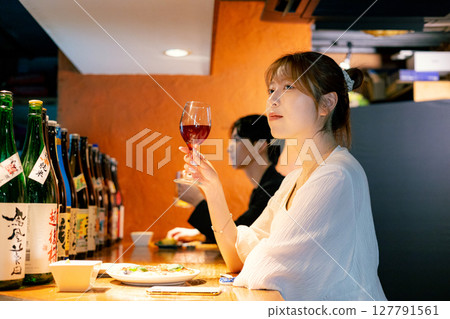 Woman eating at a bar Woman eating at a bar 127791561