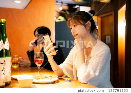 Woman eating at a bar 127791563