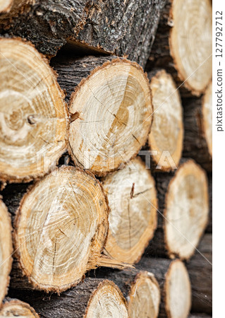 Sawn round firewood. Pile of stacked wood logs. Natural wooden background. Sawn round firewood. Pile of stacked wood logs. Natural wooden background. 127792712