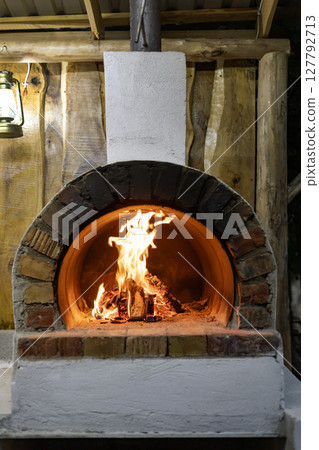 wood burning stove for outdoor cooking with burning logs inside. wood burning stove for outdoor cooking with burning logs inside. 127792713
