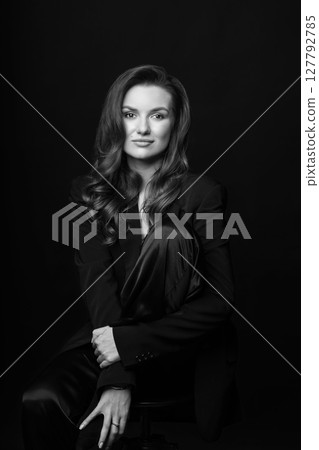 Beautiful woman with dark suit and wavy hair studio portrait 127792785