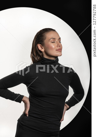 Woman with black turtle neck sweater, tight trousers and wet hair style studio portrait Woman with black turtle neck sweater, tight trousers and wet hair style studio portrait 127792788
