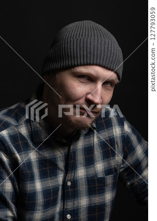 Man with winter hat and checkered shirt studio portrait 127793059