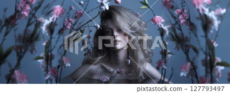 Beautiful woman with big wavy hair and flowers studio portrait 127793497