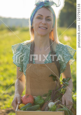 Portrait of beautiful woman picking up vegetables in garden Portrait of beautiful woman picking up vegetables in garden 127793538