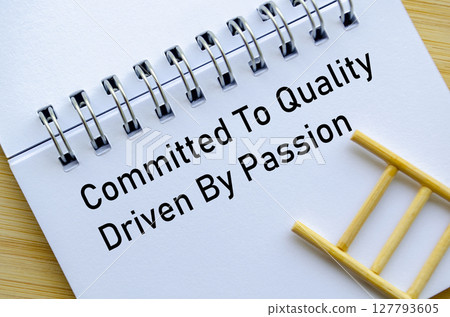 Committed To Quality Driven To Deliver Message On Notebook With Miniature Ladder On Wooden Surface Committed To Quality Driven To Deliver Message On Notebook With Miniature Ladder On Wooden Surface 127793605