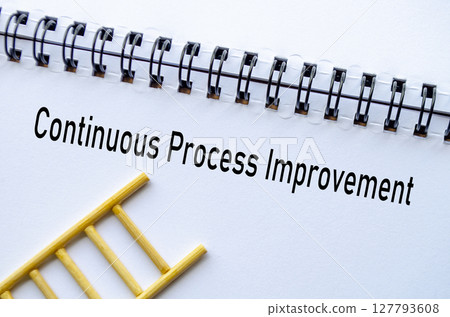 Continuous Improvement on notebook with ladder on wooden background 127793608