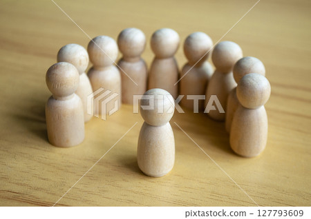 Beige Wooden Figures In Semi Circle Facing Center On Wooden Table 127793609