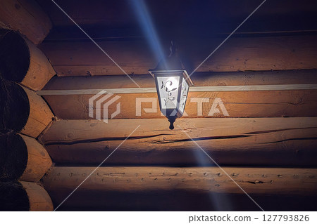 Lantern on a log wall. Lantern on a log wall. 127793826