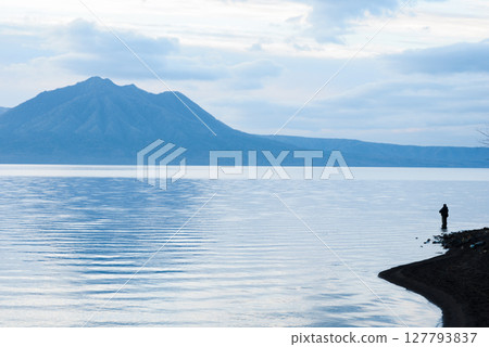 A lake and a fisherman, a moment of silence A lake and a fisherman, a moment of silence 127793837
