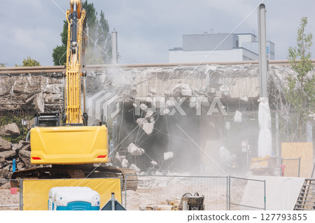Close-up view of crumbling bridge structure demolition in Magdeburg Damaschkeplatz exposed steel rebar falling concrete chunks. Rubble piles and demolition machinery emphasize destruction progress Close-up view of crumbling bridge structure demolition in Magdeburg Damaschkeplatz exposed steel rebar falling concrete chunks. Rubble piles and demolition machinery emphasize destruction progress 127793855