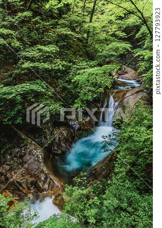 A clear waterfall basin and the soothing sound of water 127793923