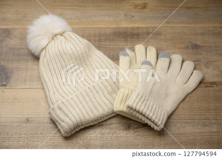 Winter knitted hats and gloves on a wooden table Winter knitted hats and gloves on a wooden table 127794594