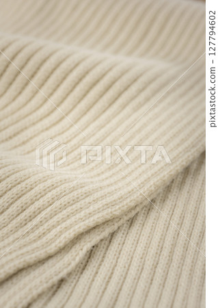 A close-up of beige knit fabric, a warm winter material A close-up of beige knit fabric, a warm winter material 127794602