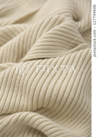 A close-up of beige knit fabric, a warm winter material 127794606