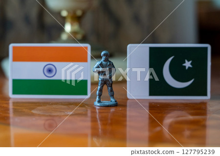 A tin soldier on the background of the flags of India and Pakistan. India Pakistan military conflict 127795239