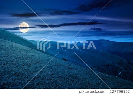 discover the beauty of mountain landscape in summer at night. beautiful scenery of ridge with great peak in full moon light 127796592