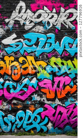 Colorful graffiti artwork on urban brick wall with vibrant blue, pink, orange, and white lettering. Street art background for creative design 127796916