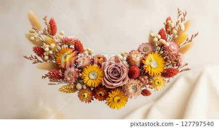 Luxurious dried flower crown featuring warm autumn roses and golden blooms on silk backdrop 127797540