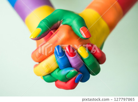 Vibrant Rainbow Painted Hands Clasped Together Symbolizing Unity and Creative Expression 127797865