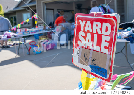 Selective focus on a yard sale sign with blurred tables of material Selective focus on a yard sale sign with blurred tables of material 127798222