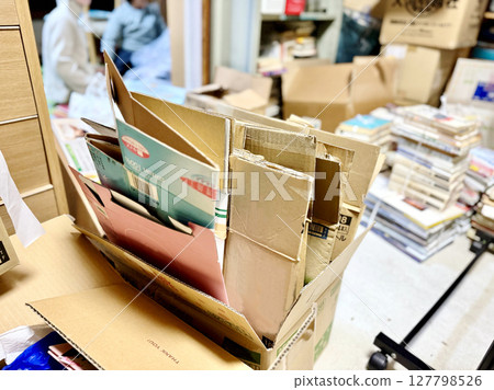 The person behind the cardboard box being decluttered The person behind the cardboard box being decluttered 127798526