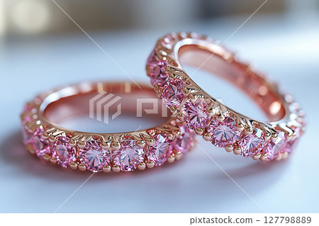 Luxurious pair of wedding rings with pink stones on a white background. Rococo-Renaissance style. 127798889