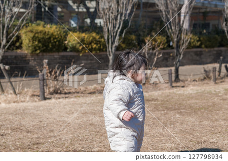 [A one-year-old child playing on the grass at Sagamihara Municipal Asamizo Park] 127798934