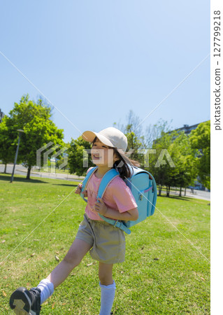 一個微笑女孩步行去學校的場景 一個微笑女孩步行去學校的場景 127799218
