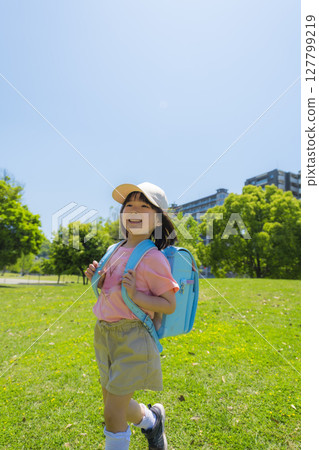 A scene of a smiling girl walking to school A scene of a smiling girl walking to school 127799219