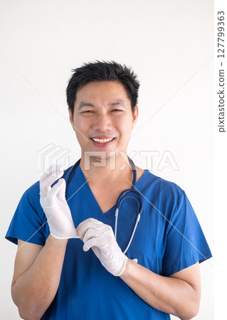 Portrait of a confident Asian male nurse wearing blue medical scrubs Portrait of a confident Asian male nurse wearing blue medical scrubs 127799363