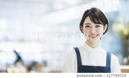 Portrait of a smiling Japanese female staff member - Bright and clean image of a cafe/store 127799724