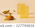 Turmeric soap bars with raw turmeric roots and wooden spoon with turmeric powder. Natural and organic ingredients for skincare. Close up. 127799838