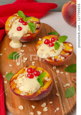 Grilled peaches with yogurt gooseberries and mint leaves on wooden table Grilled peaches with yogurt gooseberries and mint leaves on wooden table 127799858