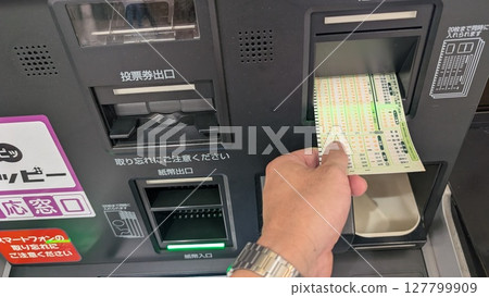 A scene of someone purchasing a betting ticket | Operating an automatic ticket vending machine 127799909