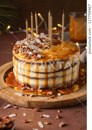 Delicious caramel cake with pecan nuts and coconut flakes 127799967