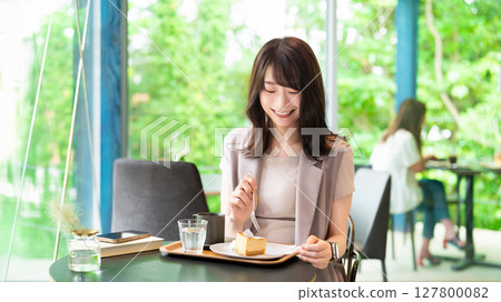 Woman eating cake at a cafe 127800082