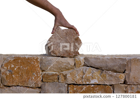 Mason hands working on masonry stone wall 127800181