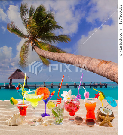 Colorful tropical cocktails at beach on white sand 127800192