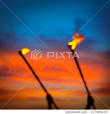 Fire torch at sunset sky with red clouds 127800234