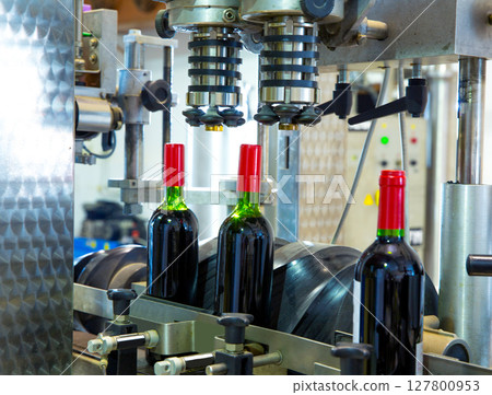 red wine in bottling machine at winery 127800953