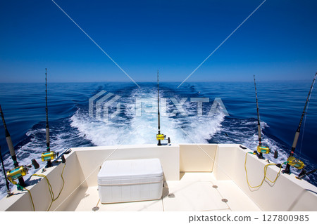 Fishing boat stern deck with trolling fishing rods and reels 127800985