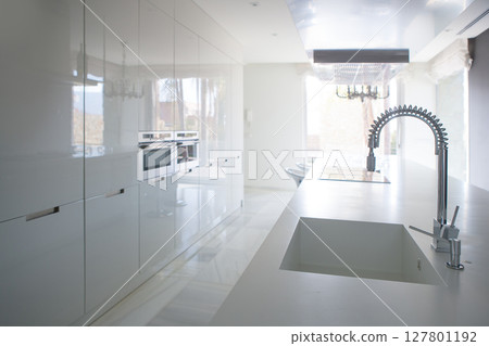 Modern white kitchen perspective with integrated bench Modern white kitchen perspective with integrated bench 127801192