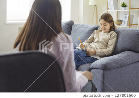 Child psychology session, talk therapy, counseling or tutoring, kid holding notebook and pencil Child psychology session, talk therapy, counseling or tutoring, kid holding notebook and pencil 127801600
