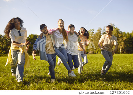 Happy friends fun, running outdoors in green park, laughing, embracing each other Happy friends fun, running outdoors in green park, laughing, embracing each other 127801602