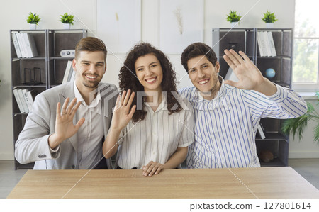 Happy business people waving hand looking at camera having online webinar or video call in office 127801614