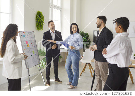 Business people standing in a circle in office on a meeting discussing job project. Business people standing in a circle in office on a meeting discussing job project. 127801628