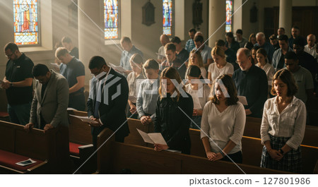 Asian Man in White T-Shirt Showing Gratitude with Praying Hands - Peaceful and Respectful Expression for Mindfulness or Wellness Concept 127801986