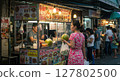 Woman Buying Street Food at Night Market in Bangkok, Thailand 127802500